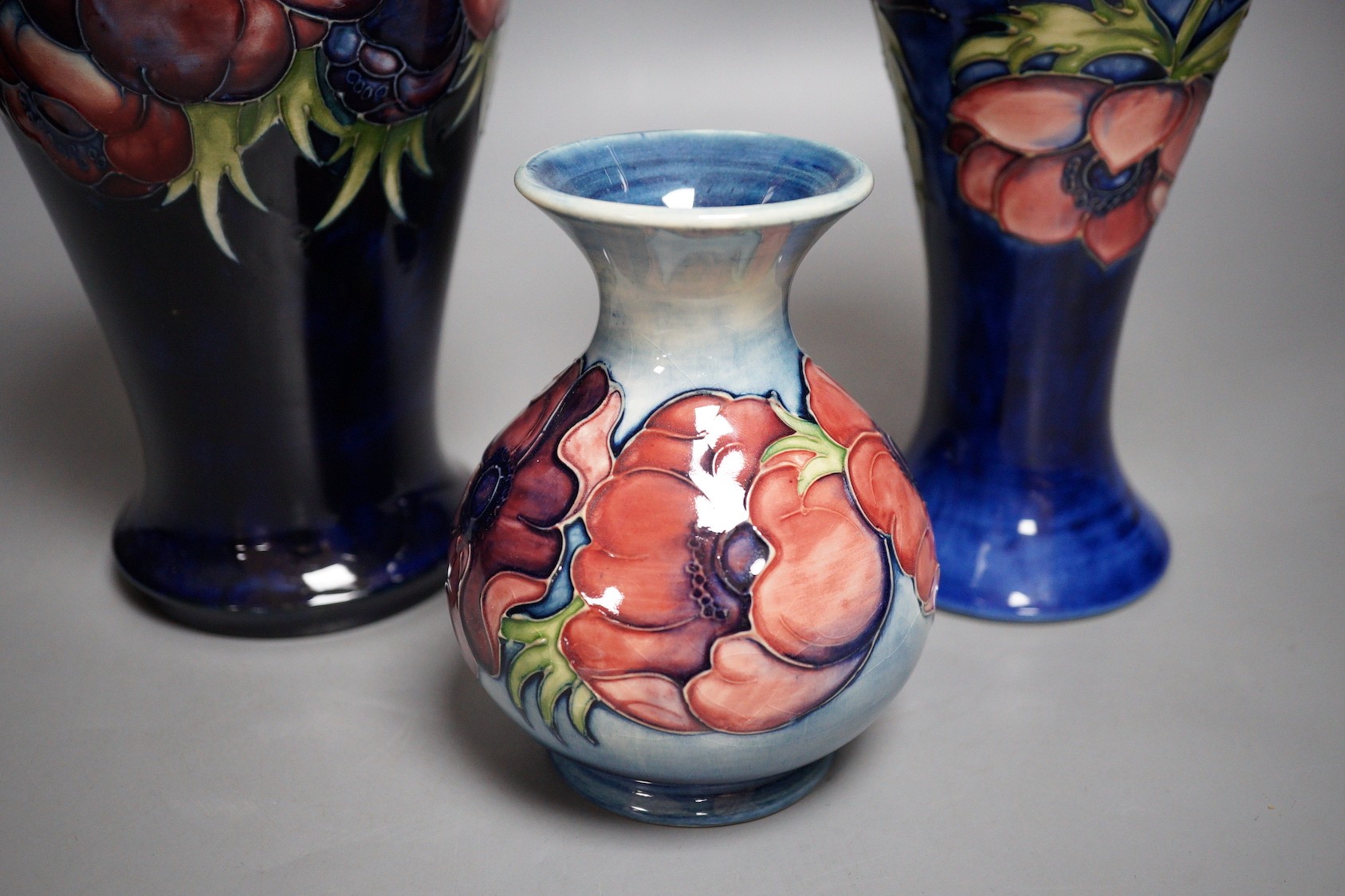 Three William Moorcroft anemone pattern vases, tallest 27cm